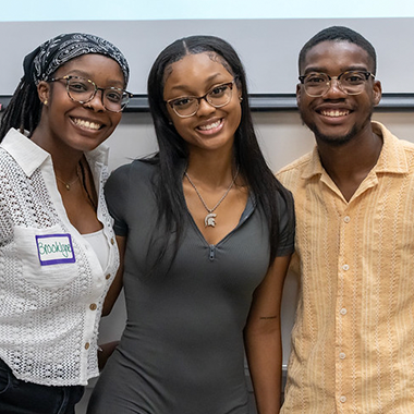 2 female students and 1 male student posing and smiling for the camera.