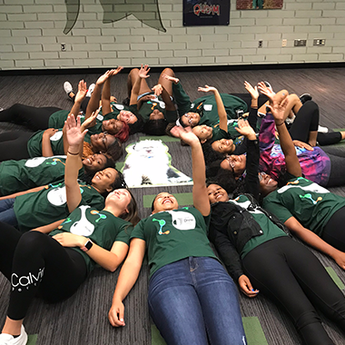 Drew students laying on the ground in a circle